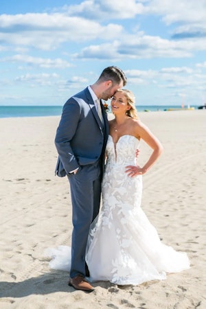 Bride wearing Hattie mermaid wedding dress by Rebecca Ingram and hugging her husband.